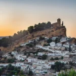 Picturesque view of Montefrio's iconic hilltop church and town at sunset.