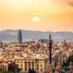 A stunning sunset view of the Barcelona skyline showcasing iconic landmarks and a warm, golden hour glow.