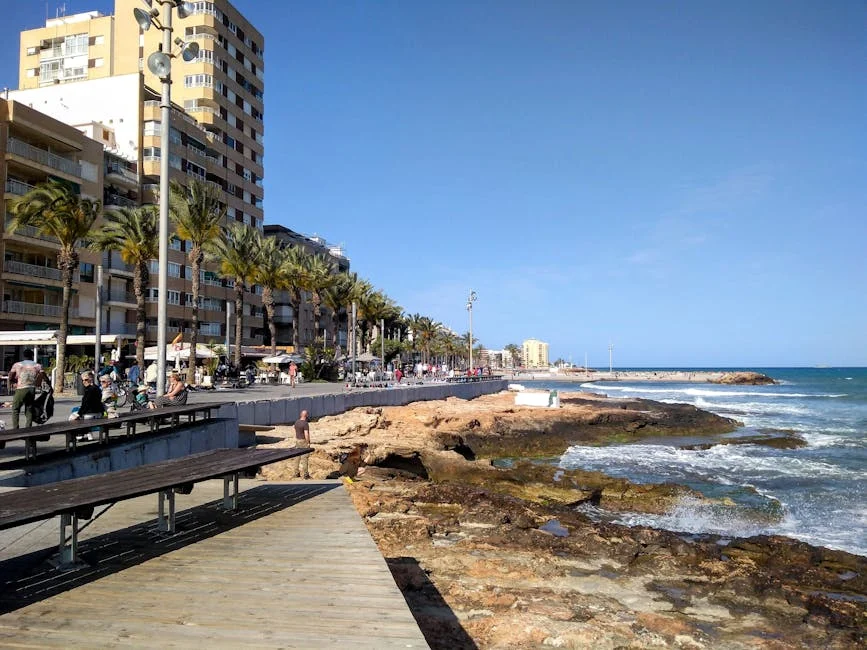 A vibrant view of Torrevieja's seafront promenade and beach on a sunny day, ideal for summer travel concepts.